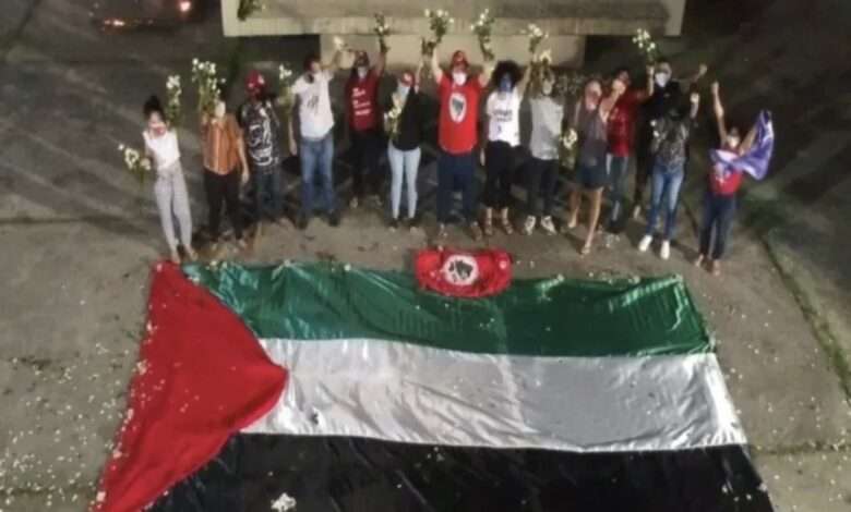 Na Imagem, Integrantes Do MST Posam Próximos À Bandeira Da Palestina